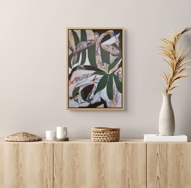 Framed abstract art piece on a wall above a wooden console table with decorative items.