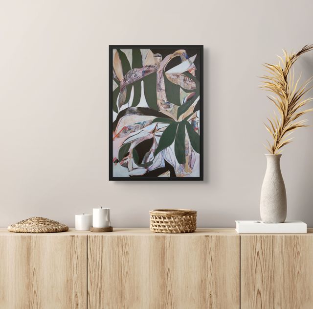 Framed abstract art piece on a wall above a wooden console table with decorative items.