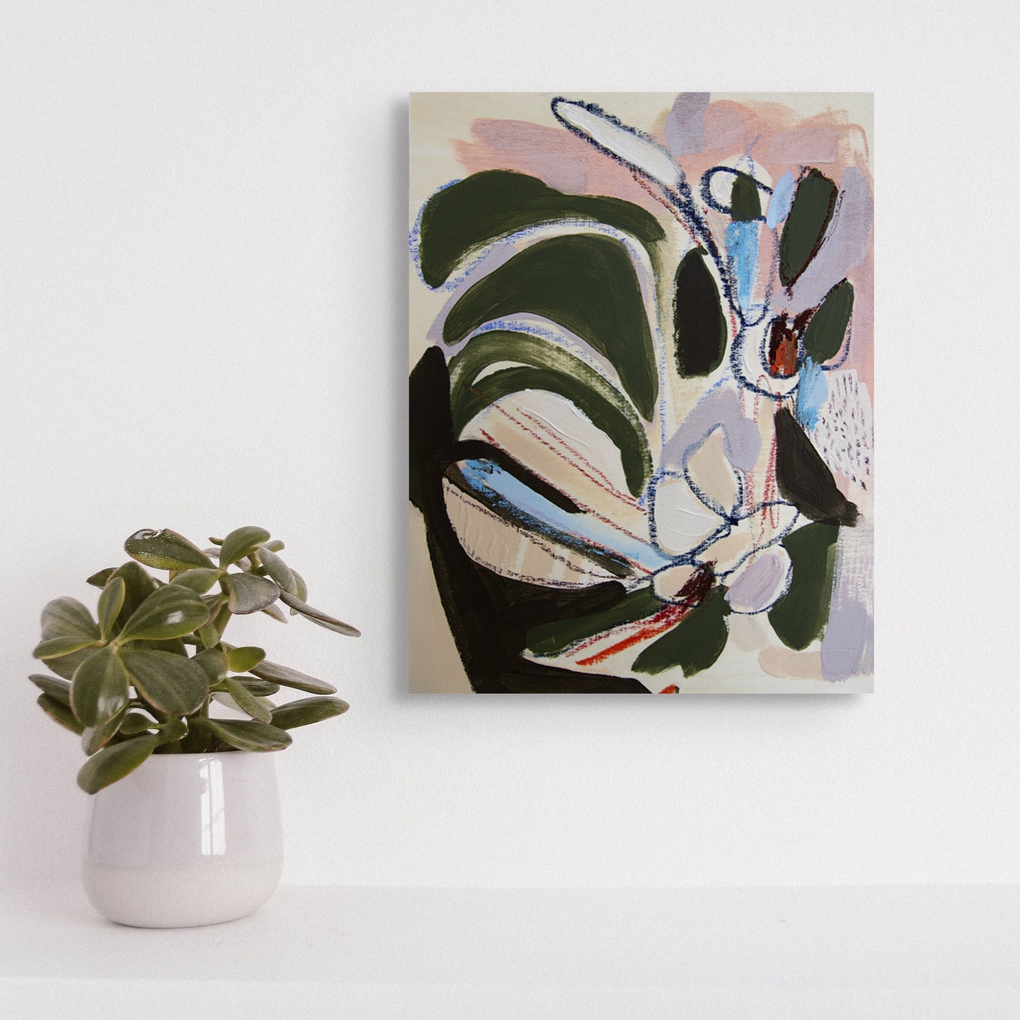 Abstract painting on a white wall with a small potted plant below.